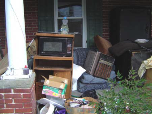Trash a furniture piled in houses' front porch