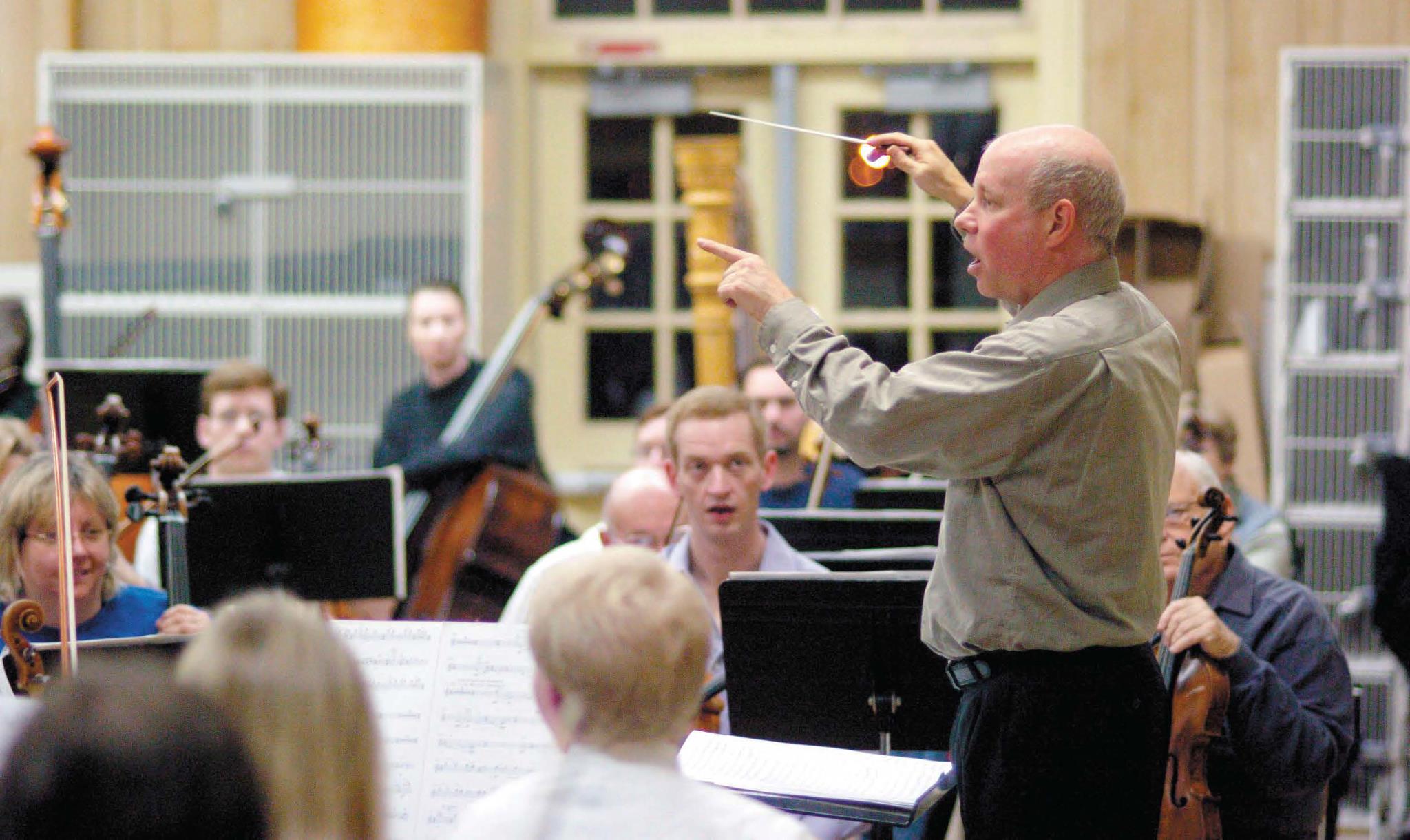 The conductor leading the symphony during a concert